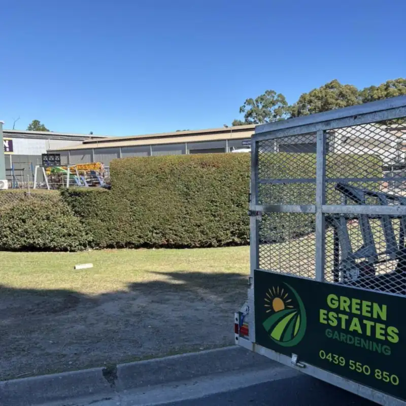 Green Estates Gardening branded trailer on site at a Moreton Bay lawn mowing job