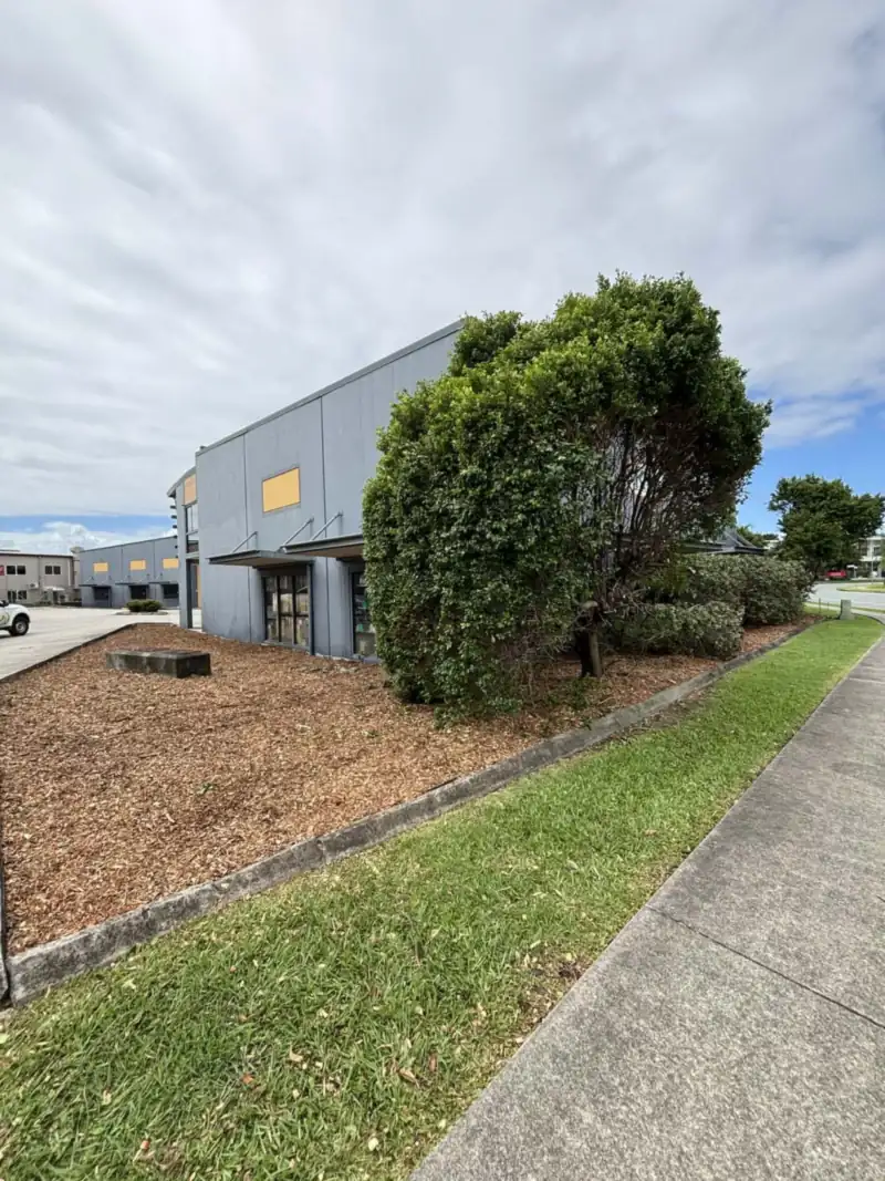 Mulching services Moreton Bay: freshly mulched garden bed along a commercial building